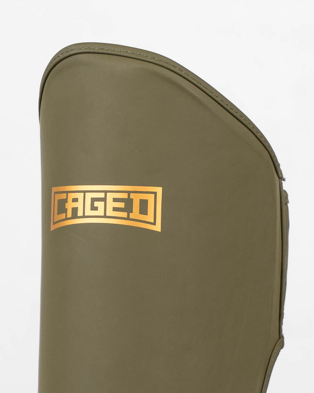 Ochraniacze na piszczele Caged Shadow – Khaki/Złoto